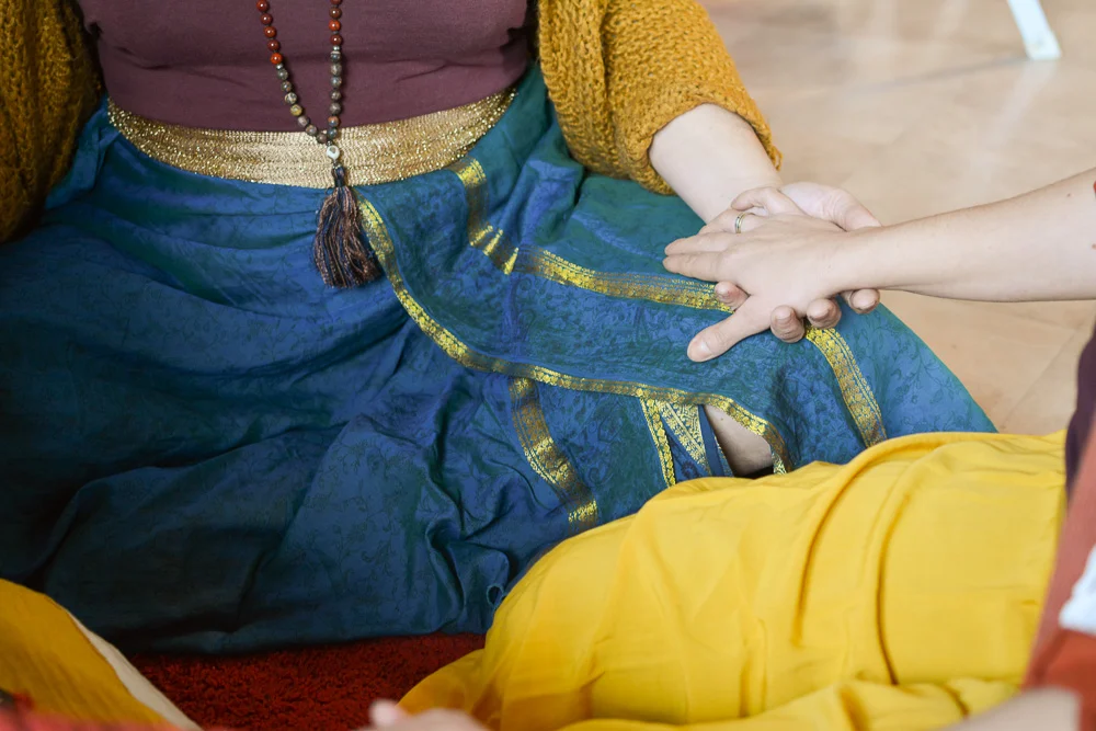Mains posées pour un massage déstressant, tissus bleu et jaune